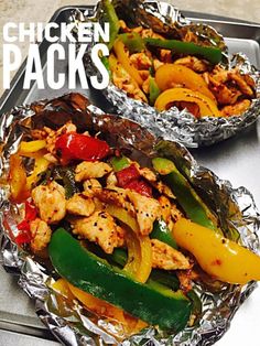 chicken and peppers in foil packets sitting on a stove top with the words chicken packs above them