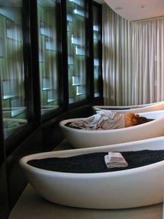 two bath tubs in a bathroom with black and white decor on the wall behind them