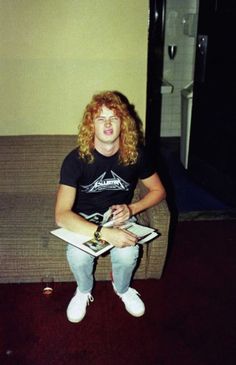 a man sitting on top of a couch holding a book