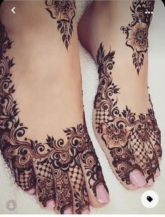 a woman's feet with henna tattoos on them