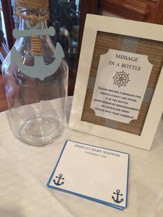 a message in a bottle next to a card and an anchor on a tablecloth