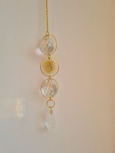 a gold necklace with three sun and two moon charms hanging from it's sides