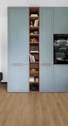 a kitchen with blue cupboards and wooden flooring in it's center area