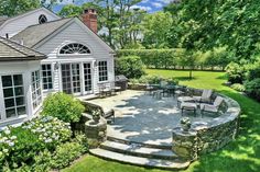 an outdoor patio with chairs and tables next to a house