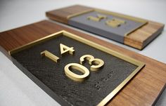 two wooden plaques with gold letters and numbers on them, one in the shape of an arrow