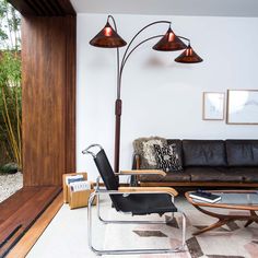 a living room with a couch, chair and floor lamp in front of the window