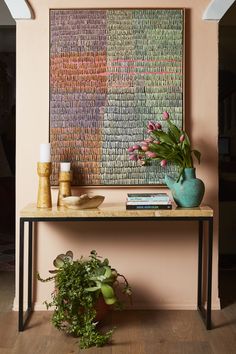 there is a vase with flowers on the table next to books and other things in front of it