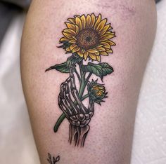 a sunflower tattoo on the leg of a woman