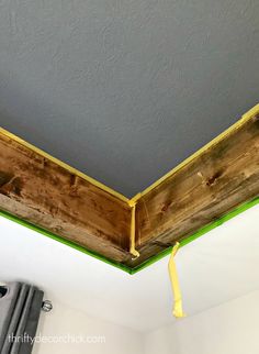 an unfinished ceiling with green tape on the bottom and yellow tape hanging from it's edge