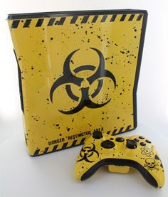 a video game controller sitting next to a yellow box with a biohazard sign on it