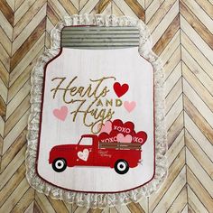 a red truck with hearts on it is hanging from the wall next to a chevron wood floor