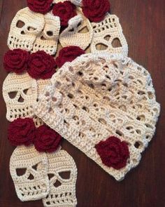 two crocheted hats with red roses on them