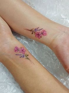 two people with matching tattoos on their feet, one has pink flowers and the other is purple