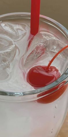 a glass filled with liquid and a red object sticking out of it's side