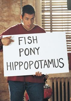 a man holding a sign that says fish pony hippopotamus