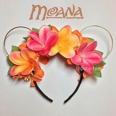 a close up of a mouse ears with flowers on it and the word meana written in large letters