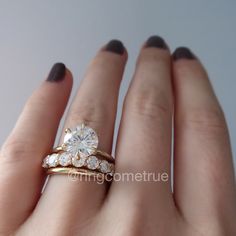 a woman's hand with two rings on it and a diamond in the middle