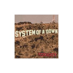 a sign that says system of a down on top of a hill with an oil rig in the background