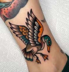 a foot with a bird tattoo on it