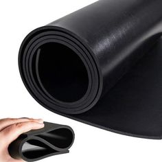 a hand holding a mouse next to a black yoga mat on white background with space for text