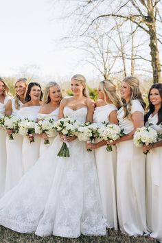 a group of women standing next to each other holding bouquets