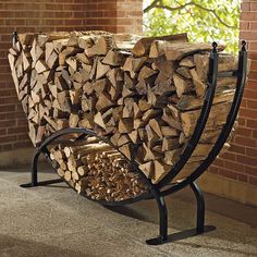 a bench made out of logs in front of a brick wall and tree trunk structure