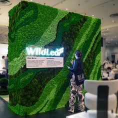 Moss Wall of Wildleaf at ICFF, with green wavy lines and lighted logo. #mosslogo #mosswall #mossart #lightedmosswall #preservedmoss Moss Logo, Green Wall