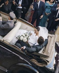 the bride and groom are in an old car