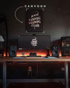 a desk with speakers and a computer on it in front of a sign that says anti coping club