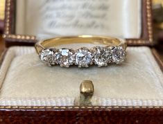 an antique five stone diamond ring in a box