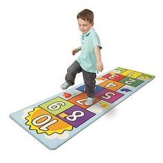 a young boy is playing on a mat with numbers