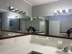 a person taking a selfie in the bathroom mirror with their reflection on the wall