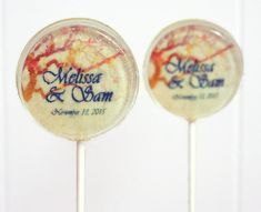 two lollipops with the names of their wedding and date on them, sitting side by side