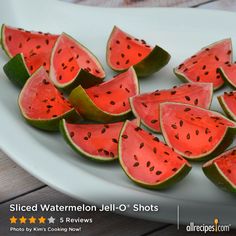 slices of watermelon are arranged on a white plate