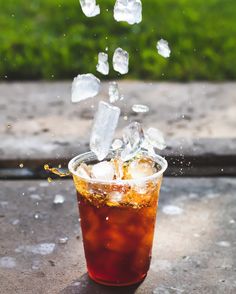 an iced drink with ice cubes falling into it