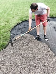 a man with a broom is cleaning the grass on top of a trampoline