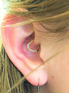 a close up of a person's ear with a small diamond hoop on it