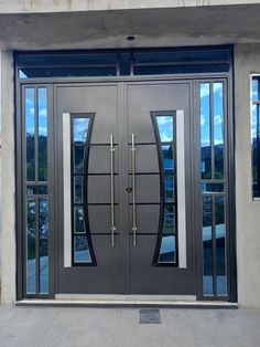 the front door to a building with two double doors and glass panels on each side