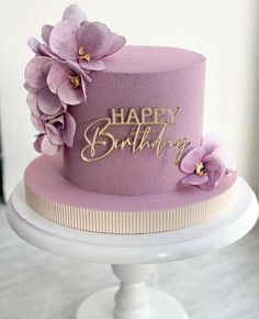 a purple birthday cake with flowers on top