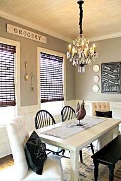 a dining room table with chairs and a chandelier hanging from it's ceiling