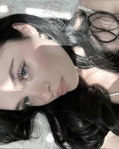 a woman with long black hair laying down