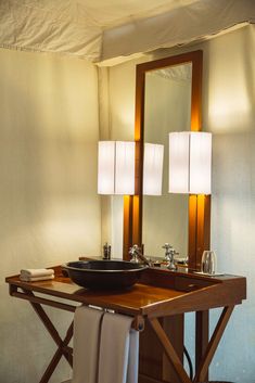 a bathroom with a sink, mirror and two lights on the side of the wall