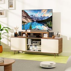 a flat screen tv sitting on top of a wooden entertainment center in a living room