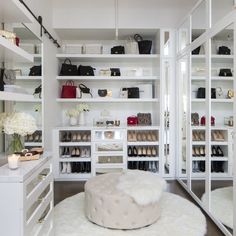 a closet with white shelving and lots of shoes on the floor, flowers in vases