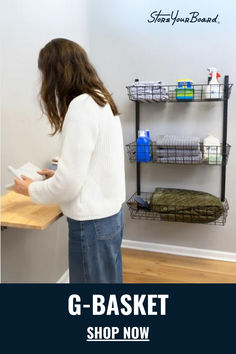 a woman standing in front of a shelf with baskets on it and the text g - basket shop now