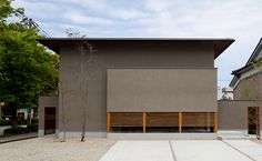 an empty parking lot in front of a building with wooden slats on the side