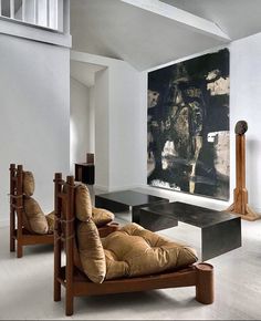 a living room filled with furniture and a painting on the wall