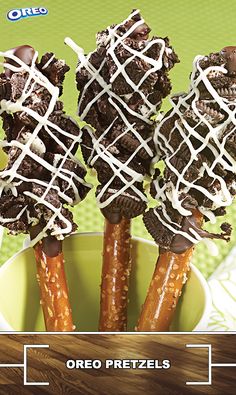 oreo pretzels with chocolate drizzled on them in a green bowl