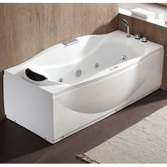 a white bath tub sitting on top of a wooden floor