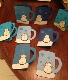 snowman coffee mugs are sitting on a table with blue and white cups in the shape of snowmen